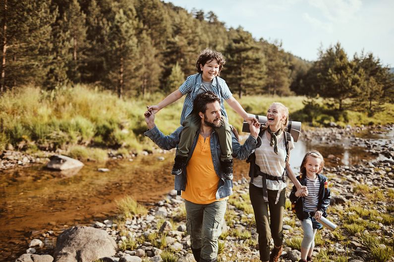 Familie wandert einen Bach entlang