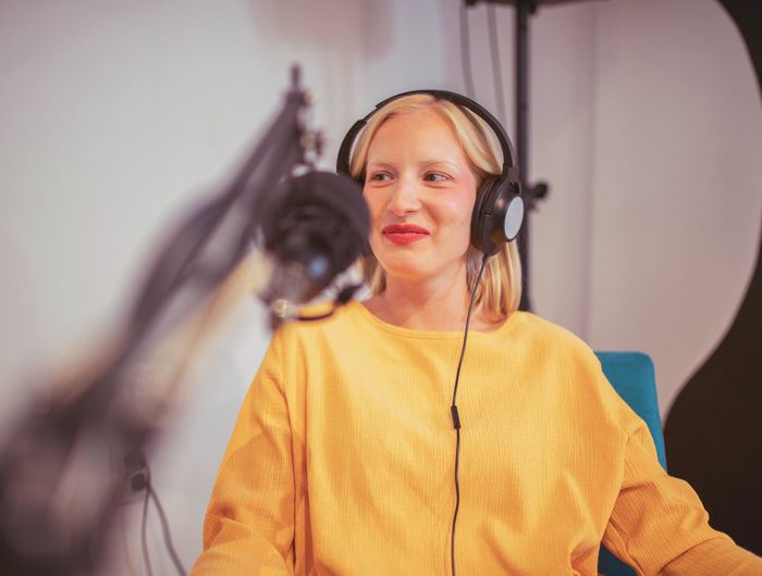 Junge Frau während der Podcast-Aufnahme
